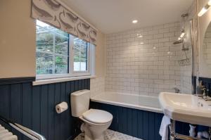 a bathroom with a toilet and a tub and a sink at 3 Bed in Fowey oc-p00871 in Fowey