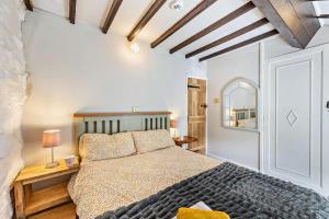 a bedroom with a large bed and a mirror at 3 Bed in Fucheswen oc-c29607 in Blaenau-Ffestiniog