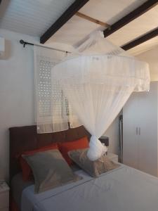 a bedroom with a bed with a white canopy at LE VERDOYANT in Sainte-Anne