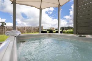 a jacuzzi tub with an umbrella in a yard at 1 Bed in Tunstall oc-p30379 in Tunstall
