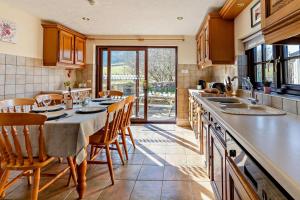 a kitchen with a table and some chairs and a counter at 3 Bed in Pentre Bach oc-t30863 in Pentre-bâch