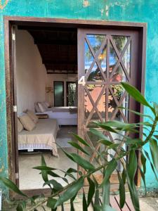 a room with a bed and a door with a window at Pouso Sabiá Suítes in Paraty