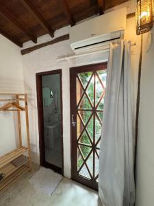 a bathroom with a shower door and a toilet at Pouso Sabiá Suítes in Paraty +87 photos
