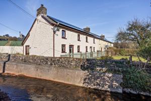 a white house sitting next to a body of water at 3 Bed in Pentre Bach oc-t30863 in Pentre-bâch