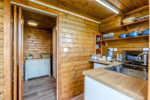a kitchen with wooden walls and a counter with a sink at 1 Bed in Latchley oc-l31925 in Sydenham Damerel