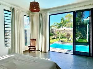 a bedroom with a bed and a view of a pool at Résidence Azélina 2 in Pointe aux Canonniers