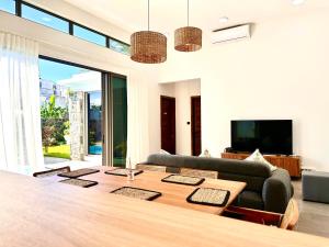 a living room with a table and a couch at Résidence Azélina 2 in Pointe aux Canonniers