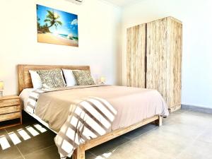 a bedroom with a large bed with a wooden headboard at Résidence Azélina 2 in Pointe aux Canonniers +15 photos