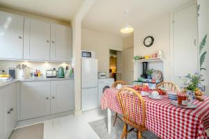 a kitchen with a table with a red and white table cloth at 2 Bed in Dymchurch oc-s31998 in Dymchurch +11 photos