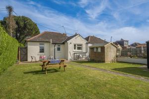 a backyard with a wooden bench in the grass at 2 Bed in Dymchurch oc-s31998 in Dymchurch