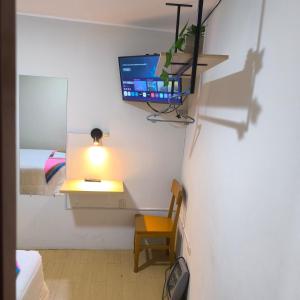 a room with a tv and a chair and a lamp at Hospedaje Samay Lodge - autogestionado in Chivay
