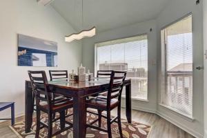 a dining room with a table and chairs and windows at Shipwrecked Getaway For 6 in Galveston +30 photos