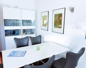 a white table with chairs and a book on it at Ferienhaus Carlo - renoviert 2025, top Lage, hundefreundlich in Glowe