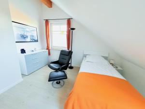 a bedroom with a bed and a desk and a chair at Ferienhaus Carlo - renoviert 2025, top Lage, hundefreundlich in Glowe