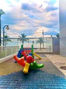 a childrens play set on a sidewalk with the ocean at Piscina Lazer Frente ao Mar in Mongaguá