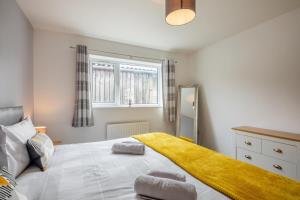 a bedroom with a large bed with a yellow blanket on it at 2 Bed in Pickering oc-d32743 in Pickering