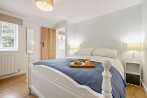 a white bedroom with a large bed with a tray on it at 2 Bed in Dersingham oc-b27417 in Dersingham