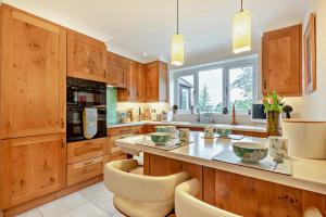 a kitchen with wooden cabinets and a counter with chairs at 3 Bed in Thornham oc-m28084 in Thornham