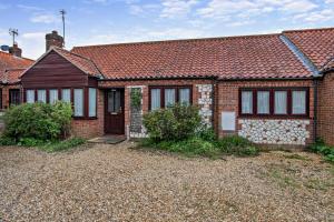 a brick house with a red roof at 3 Bed in Thornham oc-m28084 in Thornham