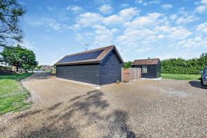 a barn with a metal roof on a gravel driveway at 2 Bed in Feering oc-p29293 in Feering