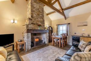 a living room with a stone fireplace and a table at 2 Bed in Eggleston oc-s30453 in Middleton in Teesdale