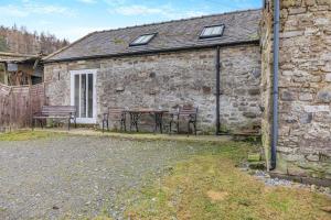 a stone cottage with a table and benches in front of it at 2 Bed in Eggleston oc-s30453 in Middleton in Teesdale