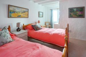 a bedroom with two beds with red sheets and a window at 2 Bed in Porthleven oc-stmich in Porthleven