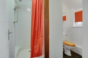 a bathroom with a toilet and a red shower curtain at 2 Bed in Porthleven oc-stmich in Porthleven