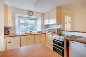 a kitchen with white cabinets and a clock on the wall at 2 Bed in Hawes oc-ds1041 in Hawes +20 photos