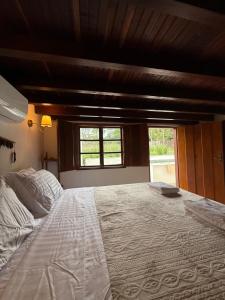 a large bed in a bedroom with a window at Casa Sol Piscina e Cachoeira in Pirenópolis +21 photos