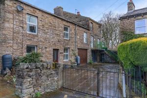 an old brick house with a fence in front of it at 2 Bed in Hawes oc-ds1041 in Hawes