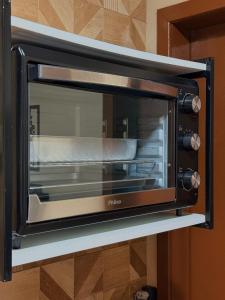 a microwave oven on a shelf in a kitchen at Pousada Reserva Verde com piscina privada com vista para a serra Studio térreo in Quatro Barras