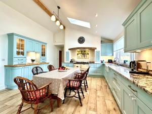 a kitchen with blue cabinets and a table with chairs at 2 Bed in Witheridge oc-b29206 in Witheridge