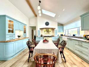 a kitchen with blue cabinets and a table and chairs at 2 Bed in Witheridge oc-b29206 in Witheridge +12 photos
