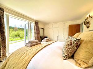a bedroom with a large bed with a large window at 2 Bed in Witheridge oc-b29206 in Witheridge