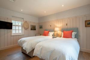 two beds with white and orange pillows in a bedroom at 3 Bed in Wittersham oc-m27683 in Wittersham