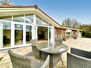a patio with a glass table and chairs at 2 Bed in Witheridge oc-b29206 in Witheridge