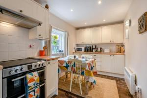 a kitchen with white cabinets and a table with chairs at 2 Bed in Burnham Overy Staithe oc-p30460 in Burnham Market
