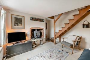 a living room with a television and a fireplace at 2 Bed in Burnham Overy Staithe oc-p30460 in Burnham Market
