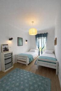 a bedroom with two beds and a chandelier at RETIRO Da CALHETA in Estreito da Calheta
