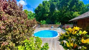 a swimming pool in a yard with a wooden deck at RAIATEA - Orion Pool Bungalow in Uturoa