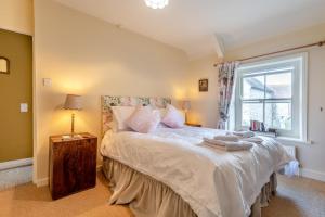 a bedroom with a large bed with a window at 3 Bed in Swanage oc-s30316 in Swanage