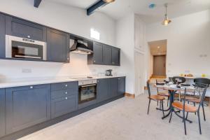a kitchen with blue cabinets and a table with chairs at 3 Bed in Burtersett oc-ds1043 in Hawes
