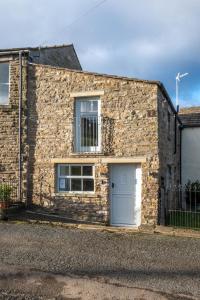 a stone house with a white door and windows at 3 Bed in Burtersett oc-ds1043 in Hawes