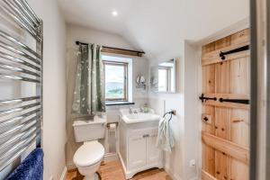 a bathroom with a toilet and a sink and a window at 4 Bed in Derwenlas oc-c29244 in Machynlleth +26 photos