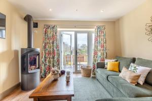 a living room with a green couch and a fireplace at 1 Bed in Pershore oc-t29049 in Pershore