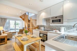 a kitchen and living room with white cabinets and a table at 2 Bed in Pooley Bridge oc-l31060 in Pooley Bridge