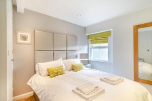 a bedroom with a large white bed with yellow pillows at 2 Bed in Pooley Bridge oc-l31060 in Pooley Bridge
