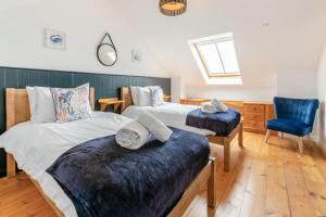 a bedroom with two beds and a blue chair at 3 Bed in Coverack oc-b31082 in Coverack