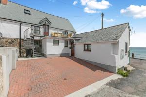 a house with a brick driveway next to the ocean at 3 Bed in Coverack oc-b31082 in Coverack